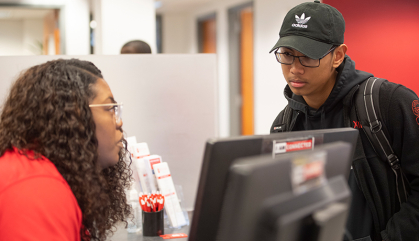 A Rutgers employee helps a student. 