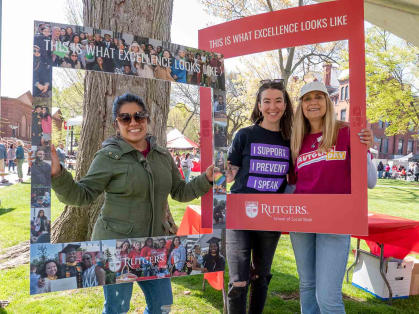 Attendees pose with School of Social Work frames during Rutgers Day 2022 on College Avenue campus.
