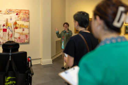 Brandon Truett (center) discusses Joan Snyder's 2011 painting "Still" with student educators in training.