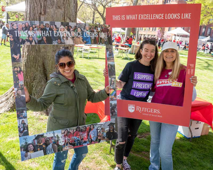 Students and a volunteer pose with School of Social Work frames during Rutgers Day 2022 on College Avenue campus.