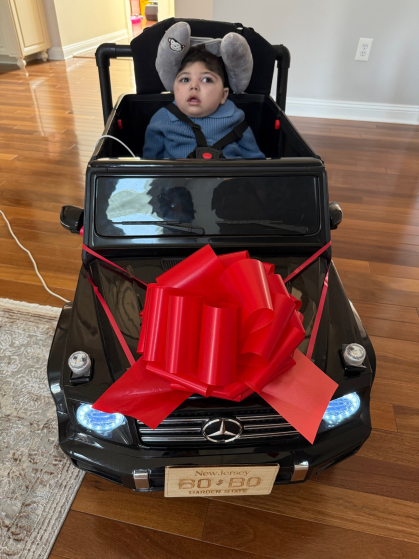 Elyas Khalid, 20 months, rides on the modified toy that A4A student club members modified for him.