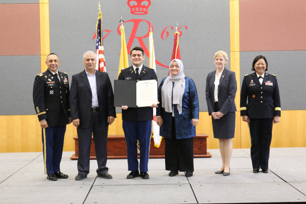 Second Lieutenant Hayreddin Kalac on stage with his parents, Cortez, Hou and Moehling