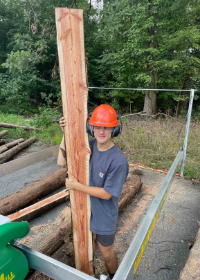 Josh Kover, a member of the Rutgers University Forestry Club's milling team, holds up a slab of dawn redwood.