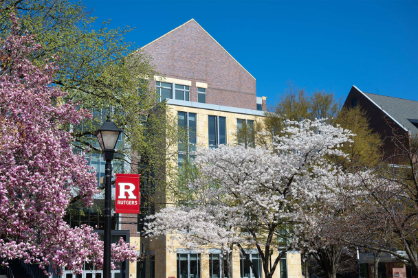 The Academic Building as seen through trees in bloom on an early spring afternoon.
