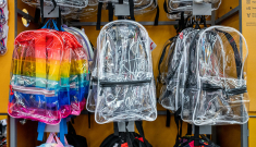 Clear back packs hanging on a wall 