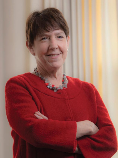 Debbie Walsh standing arms crossed in front of a window