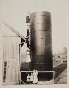 Four women on a silo, along with another woman and three children, pose in this undated photograph.